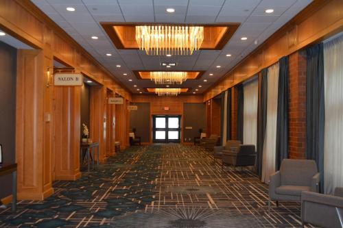 a hallway with chairs and a chandelier in a building at Delta Hotels by Marriott Mount Pleasant in Racine