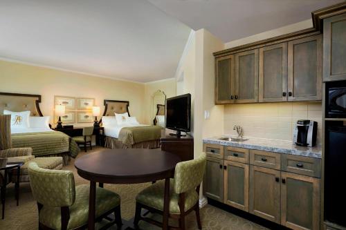 a hotel room with two beds and a kitchen with a table at The Algonquin Resort St. Andrews by-the-Sea, Autograph Collection in Saint Andrews
