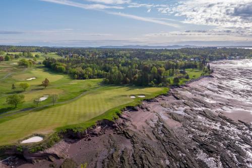 an aerial view of a golf course next to a river at The Algonquin Resort St. Andrews by-the-Sea, Autograph Collection in Saint Andrews