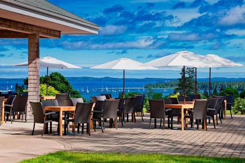 a group of tables and chairs with umbrellas at The Algonquin Resort St. Andrews by-the-Sea, Autograph Collection in Saint Andrews