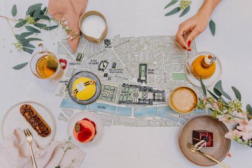 a table with a map of a city with plates of food at Renaissance Paris Vendome Hotel in Paris