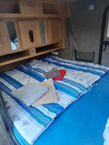 a bed in the back of a vehicle with towels at Gästehaus Kathi Campingplatz Buschcamper in Gyenesdiás