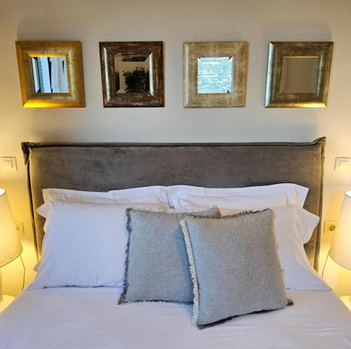 a bedroom with a white bed with four pictures on the wall at The Blooming House in Makriótika
