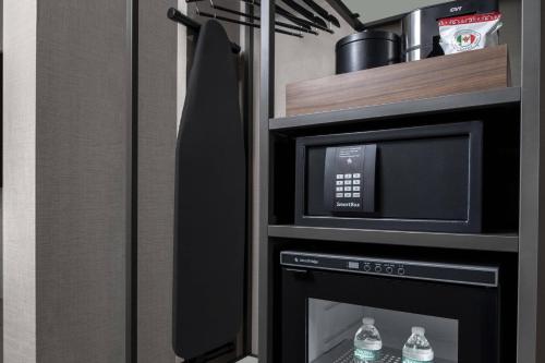 a kitchen with a microwave and a stove at AC Hotel by Marriott St Louis Central West End in Saint Louis