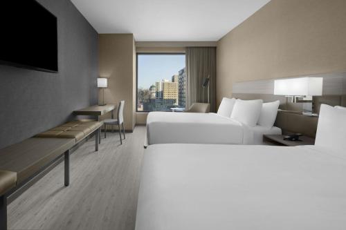 a hotel room with two beds and a window at AC Hotel by Marriott St Louis Central West End in Saint Louis
