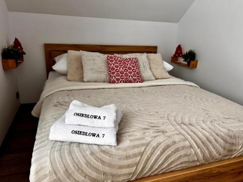 a bed with two towels on top of it at Osiedlowa 7 in Tylicz