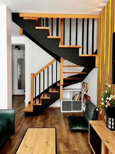 a living room with a black staircase in a house at Osiedlowa 7 in Tylicz