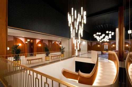 a lobby with a staircase and chandeliers at HONEYROSE Hotel, Montreal, a Tribute Portfolio Hotel in Montréal