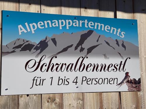 a sign on a fence with a mountain at Alpenappartements Schwalbennestl in Mittenwald
