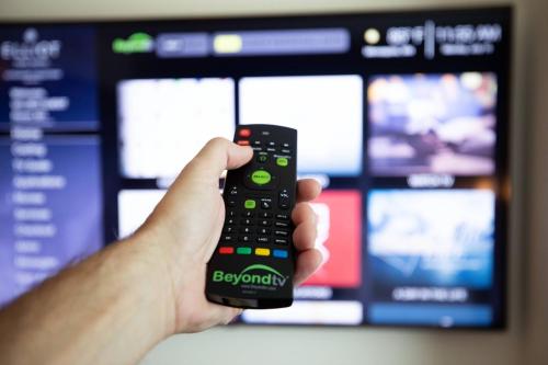 a person holding a remote control in front of a television at Elliot Park Hotel, Autograph Collection in Minneapolis
