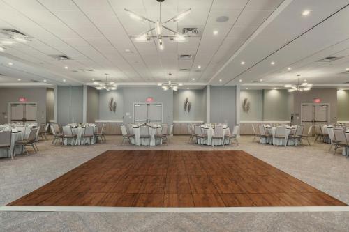 a banquet hall with white tables and chairs at Courtyard Amelia Island in Amelia Island