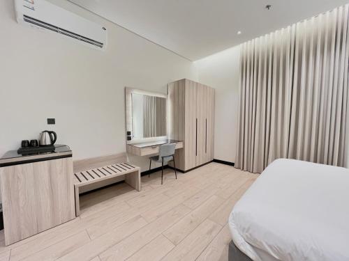 a bedroom with a bed and a desk and a sink at مهد إن شقق مخدومة جديدة Mahd Inn Hotel in Riyadh
