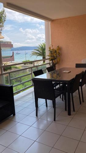 une table et des chaises avec vue sur l'océan dans l'établissement Appartement front de mer Cavalaire, à Cavalaire-sur-Mer