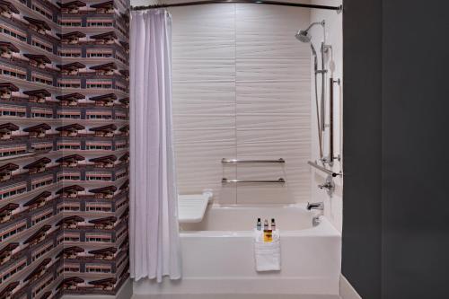 a bathroom with a tub and a sink and a shower at Aloft San Antonio UTSA Area in San Antonio