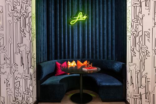 a blue couch with a table in a room at Aloft San Antonio UTSA Area in San Antonio