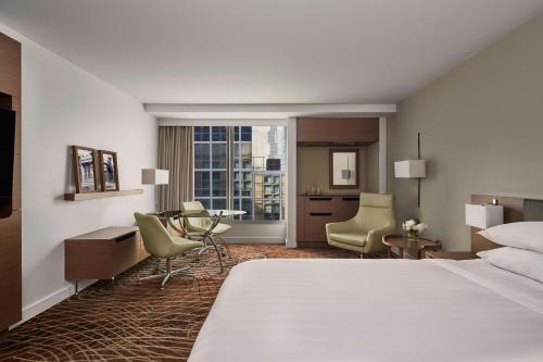 a hotel room with a bed and a desk and chairs at Melbourne Marriott Hotel in Melbourne
