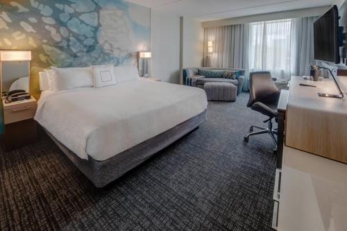 a hotel room with a bed and a desk at Courtyard by Marriott Dulles Airport Herndon in Herndon