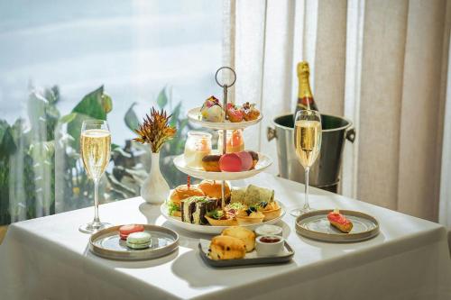 a table with three plates of food and two glasses of champagne at Melbourne Marriott Hotel in Melbourne