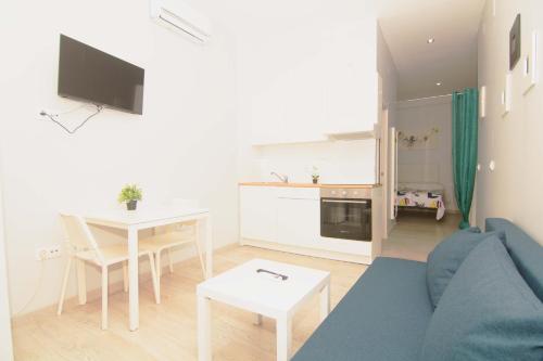 a living room with a blue couch and a table at Apartamentos Centro Puerto de Santa Maria in El Puerto de Santa María