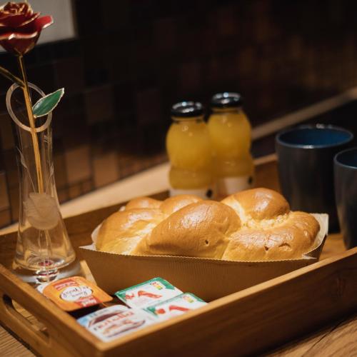 bandeja con pan y botellas de zumo de naranja en Villa-Aphrodia love room, en Thionville