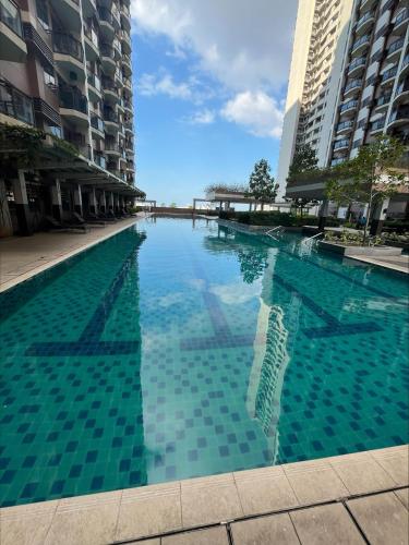 a swimming pool in the middle of some buildings at Bayfront 1BR Condo in Pasay Manila with Wi-Fi, Netflix & Pool Access, Near NAIA Airport, Mall of Asia, OKADA, CCP & PICC in Manila