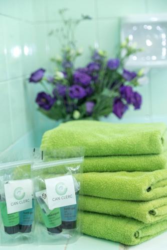 a display of green towels and a bouquet of flowers at Holiday home Can Clerc in Osor