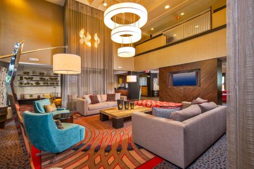 a hotel lobby with couches and chairs and a television at Courtyard by Marriott Dulles Town Center in Sterling