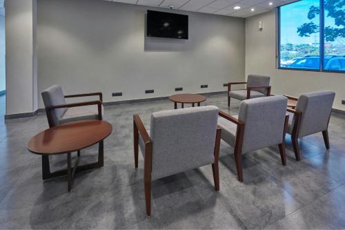 a waiting room with chairs and tables and a wall at City Express by Marriott Ciudad de México Plaza Central in Mexico City