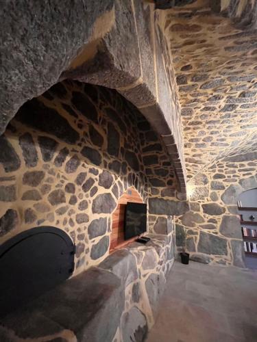 a stone room with a fireplace in a stone wall at Le gîte du parayre in Lunac