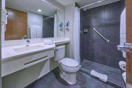 a bathroom with a toilet and a sink and a shower at City Express by Marriott Ciudad de México Plaza Central in Mexico City