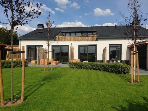 a house with a lawn in front of it at Appartementen De Wilg - Adults only in Noordwijk aan Zee