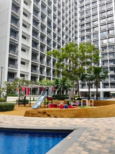 a playground in front of a large apartment building at VSV Luxury Family Suite staycation Moa shore2 tower2 unit1122 in Manila