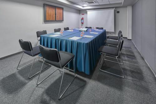 a conference room with a blue table and chairs at City Express by Marriott Ciudad de México Plaza Central in Mexico City