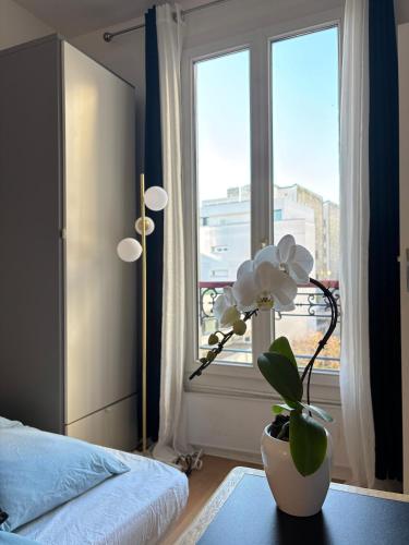 - une chambre avec une fenêtre et une fleur dans un vase dans l'établissement Bright studio, à Paris