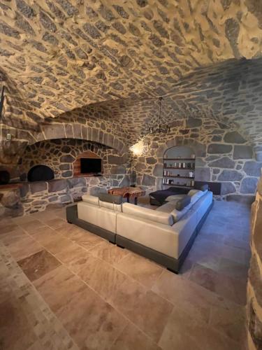 a living room with a couch and a stone wall at Le gîte du parayre in Lunac