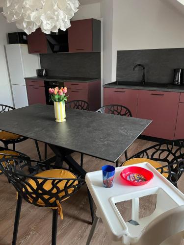 a kitchen with a table with a vase of flowers on it at NEW Modern Apartment - 93m2 Central in Pfaffenhofen an der Ilm