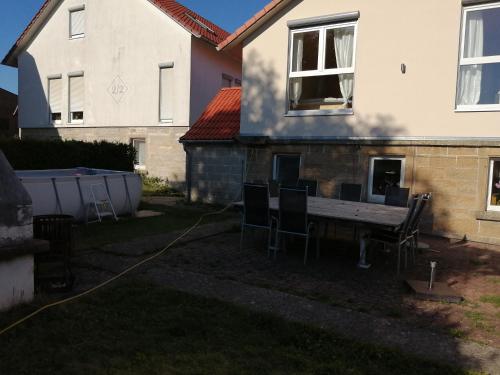 a backyard with a table and chairs in front of a house at Ferienwohnungen Waldmann in Blaufelden