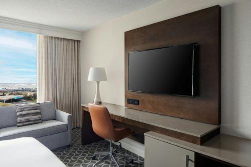 a hotel room with a television and a couch and a chair at Marriott St. Louis Airport in Edmundson