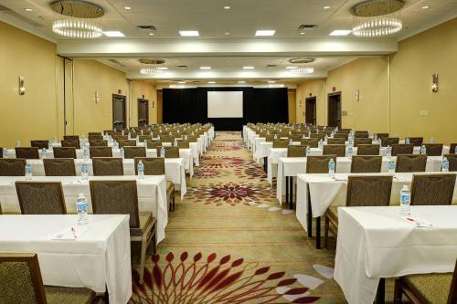 a conference room with tables and chairs and a screen at Marriott St. Louis Airport in Edmundson