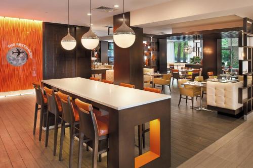 a restaurant with a bar with chairs and tables at Marriott St. Louis Airport in Edmundson