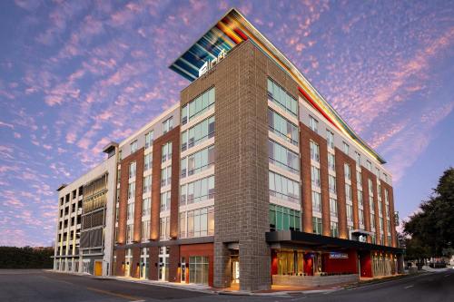 a building on a street with a cloudy sky at Aloft Savannah Downtown Historic District in Savannah