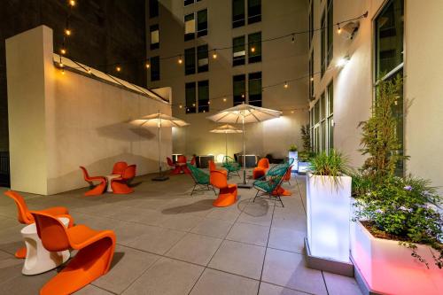 an outdoor patio with chairs and tables and umbrellas at Aloft Savannah Downtown Historic District in Savannah