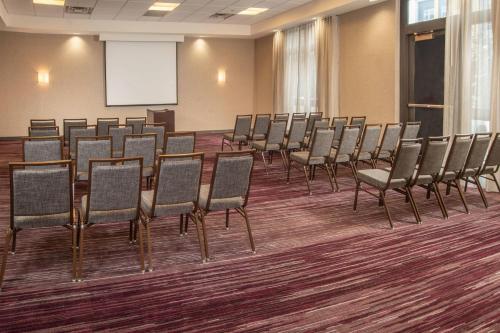 a row of chairs in a conference room with a screen at Courtyard Dunn Loring Fairfax in Merrifield