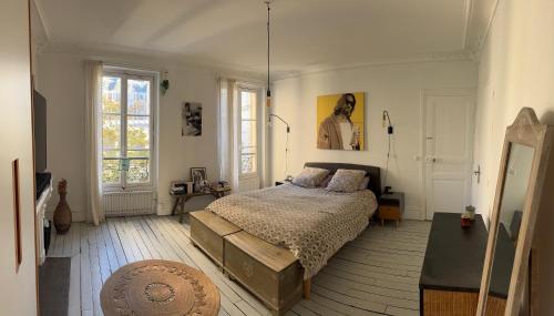 une chambre avec un lit et une grande fenêtre dans l'établissement Le Refuge Bohème, à Paris