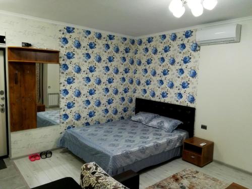 a bedroom with a bed and a blue wall at Apartment for rent number 2 in Aktau