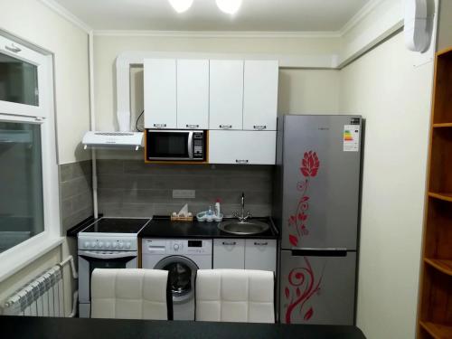 a small kitchen with a refrigerator and a microwave at Apartment for rent number 2 in Aktau