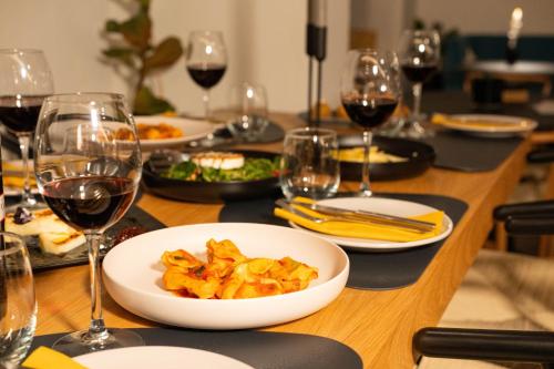 a table with plates of food and glasses of wine at Kenta Mountain Hotel & Gastrobar in Portariá