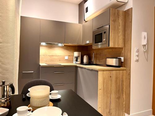- une cuisine avec une table et un four micro-ondes dans l'établissement Superbe Grand Studio avec balcon Intra-Muros, à Saint-Malo