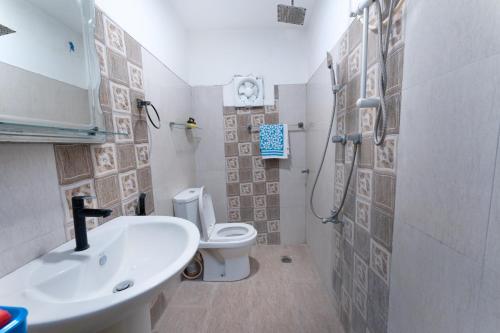 ein Badezimmer mit Waschbecken, Toilette und Dusche in der Unterkunft Kavi Villa in Bentota