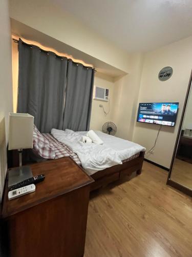 a bedroom with a bed with a dog laying on it at Bayfront 1BR Condo in Pasay Manila with Wi-Fi, Netflix & Pool Access, Near NAIA Airport, Mall of Asia, OKADA, CCP & PICC in Manila